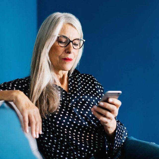 person sitting on couch looking at phone